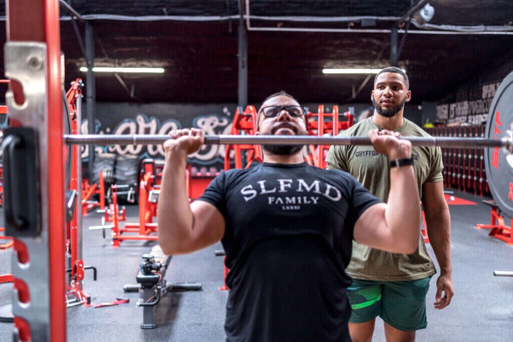 Gryffon Performance coach reviewing a client's progress during a strength training session in Dallas, TX