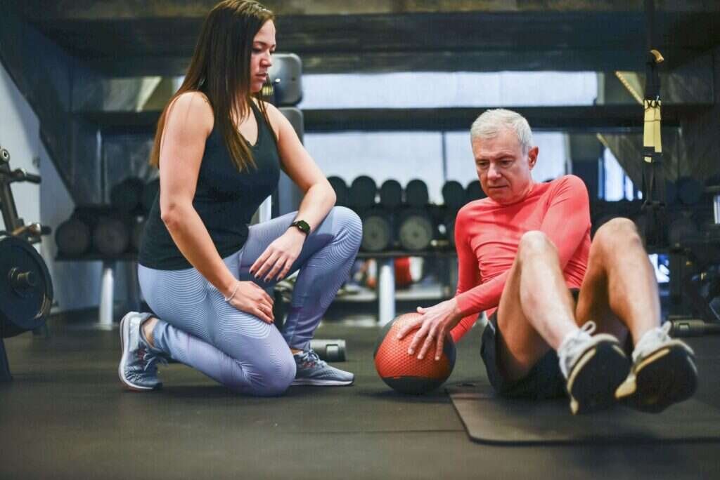 Coach observing a client's shoulder movement during a strength training session