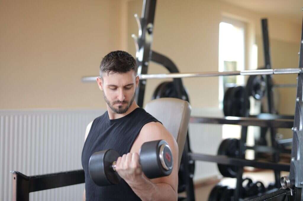 Adult man performing a dumbbell exercise during a strength training session
