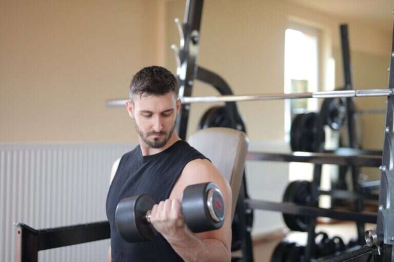Adult man performing a dumbbell exercise during a strength training session