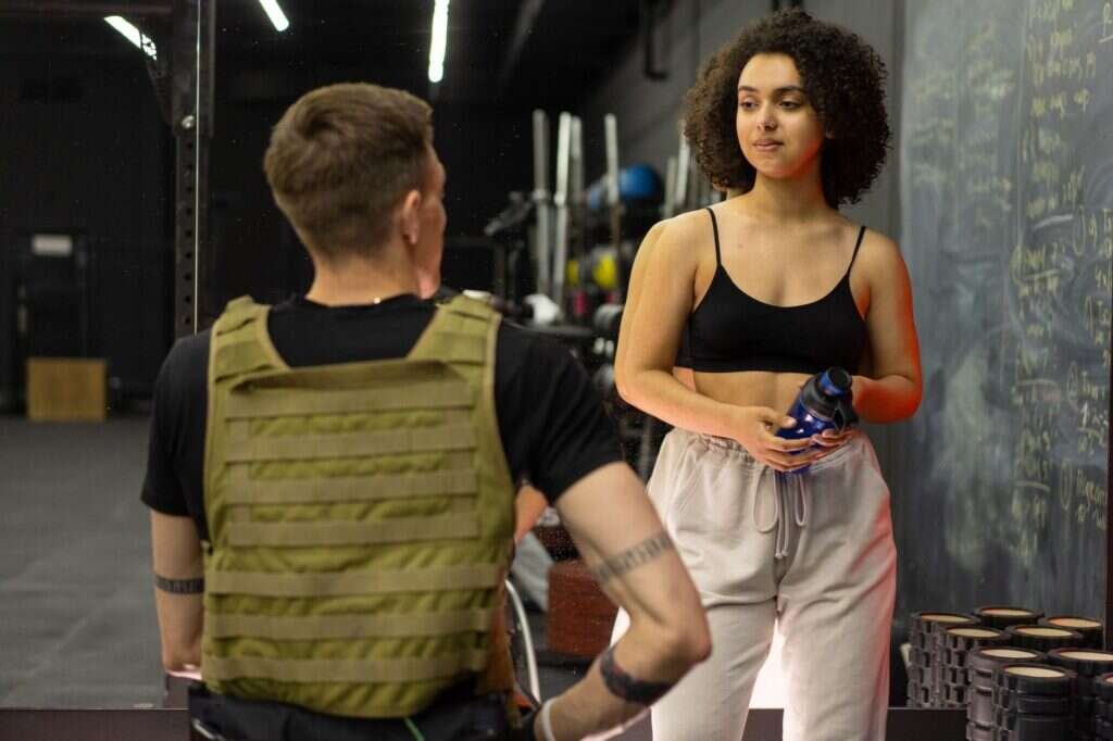 Coach and client talking through goals and training history in a gym