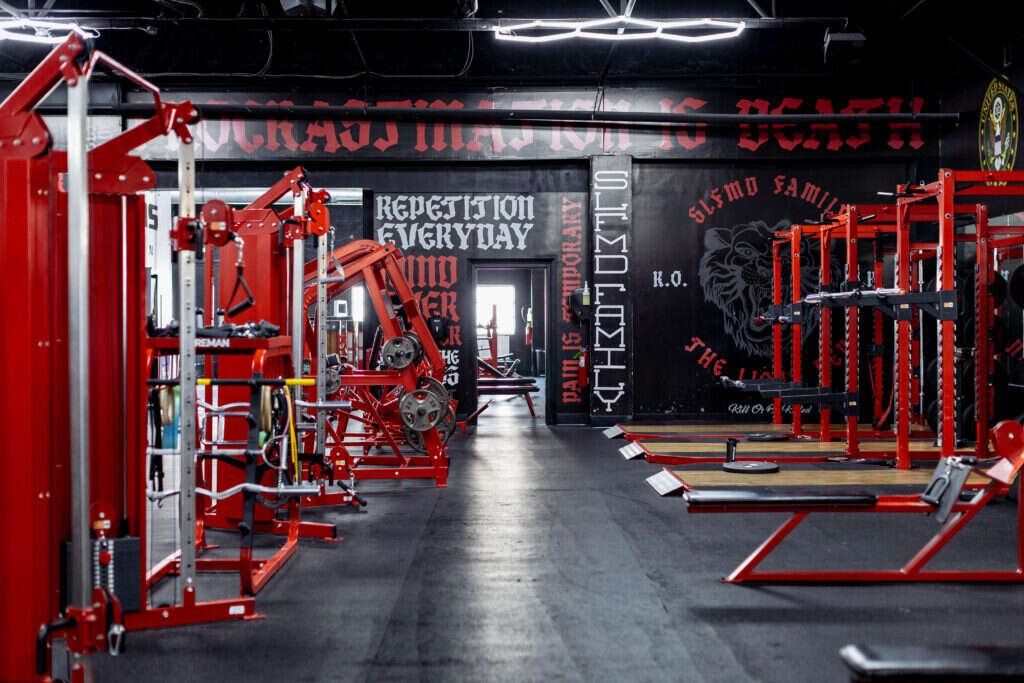 Plate-loaded strength machines and barbells inside the Gryffon Performance private training facility in Dallas