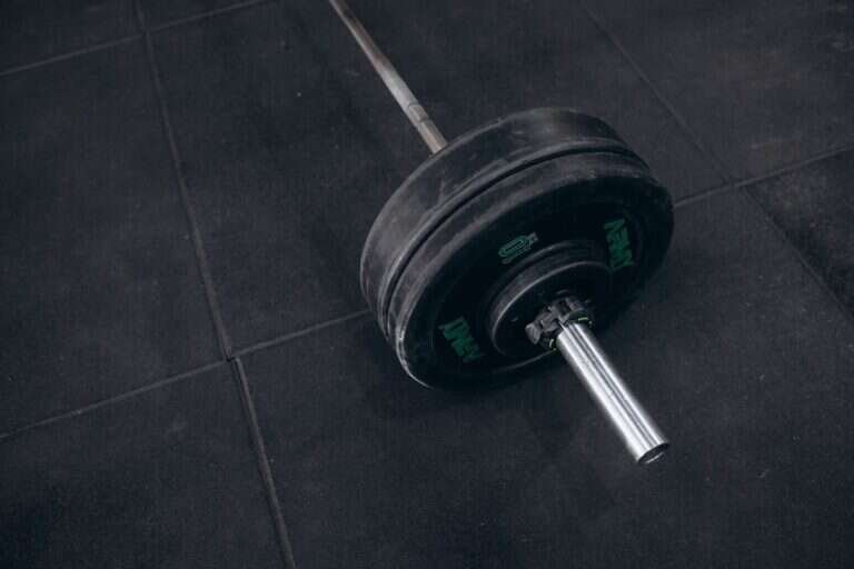 Barbell resting on a gym floor before a set
