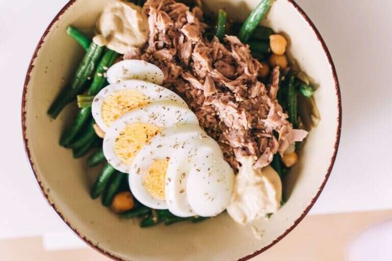 Protein-rich bowl with tuna, boiled eggs, green beans and hummus
