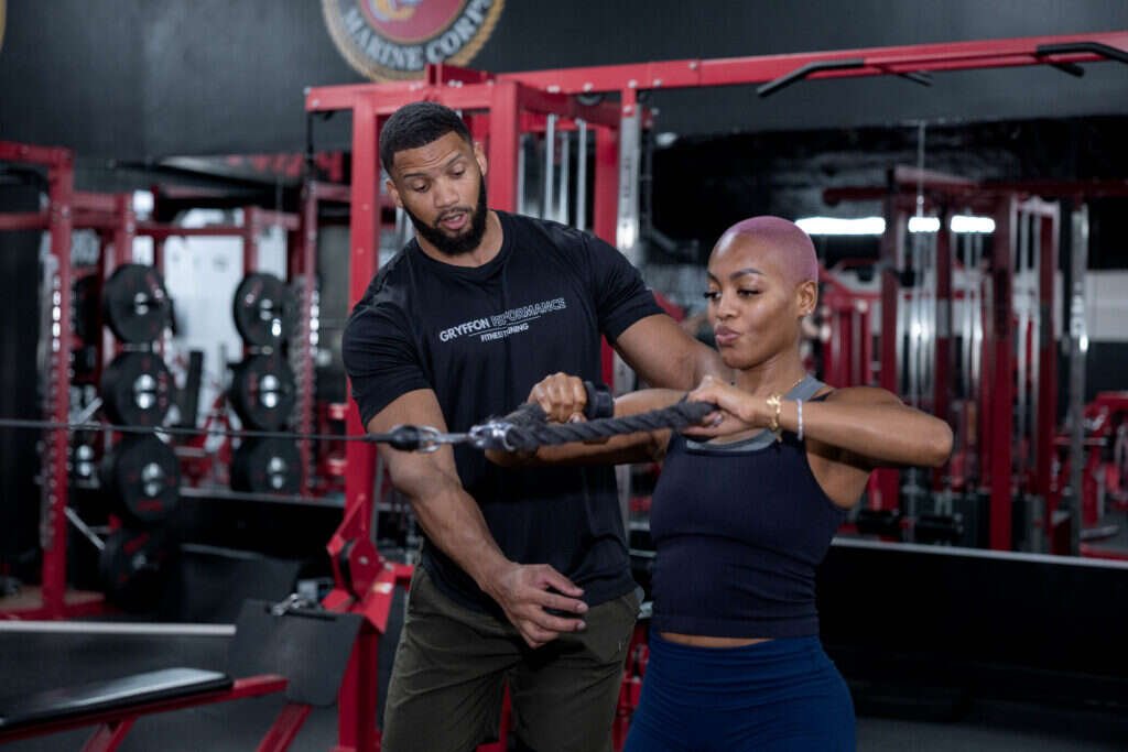 Personal trainer guiding a cable rope pull at Gryffon Performance in Dallas