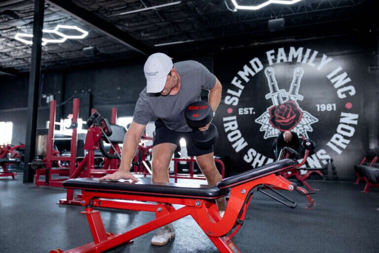 Single-arm dumbbell row on a bench at Gryffon Performance in Dallas